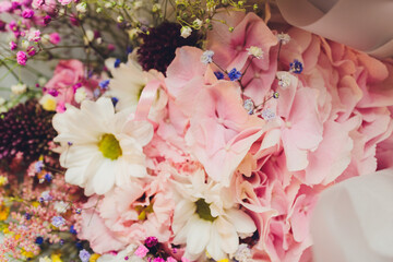 A flower bouquet with a lot of a different flowers.