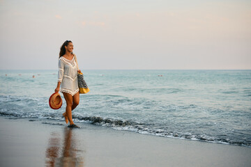 Carefree woman walking along the shore.
