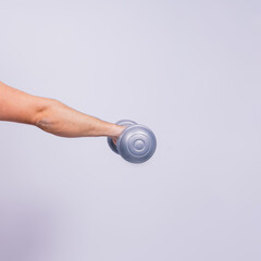 Athletic man doing exercises with dumbbell at biceps on white background. Strength and motivation
