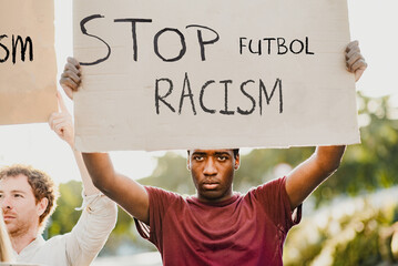 Serious young black man holding sign with Stop Racism inscription  © Gabriel Trujillo