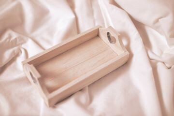 Empty wooden tray in bed, mock up