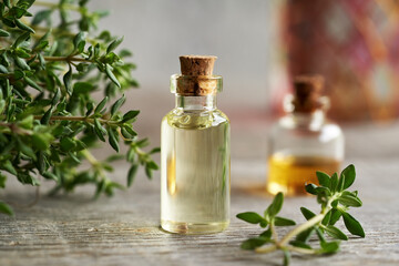 Obraz na płótnie Canvas A bottle of thyme essential oil on a table