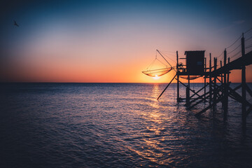 A fishing hut called carrelet with craft lifting net at sunset. Esnandes, charente maritime,...