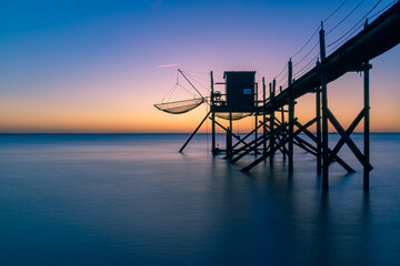 Fototapeta na wymiar Fishing hut on stilts coast of Atlantic ocean at sunset near La Rochelle, Charente Maritime, France