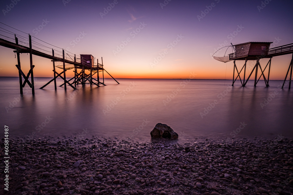 Wall mural fishing hut on stilts coast of atlantic ocean at sunset near la rochelle, charente maritime, france