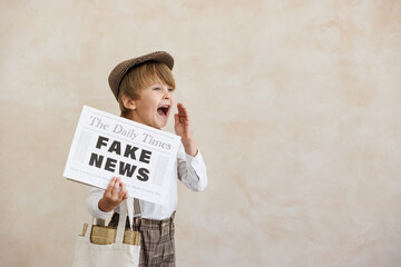 Newsboy shouting against grunge wall background. Boy selling fake news - obrazy, fototapety, plakaty