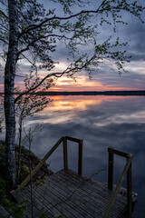 calm lake at sunset with clouds reflecting in water - 605816140