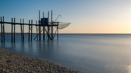 Fishing hut on stilts coast of Atlantic ocean at sunset near La Rochelle, Charente Maritime, France
