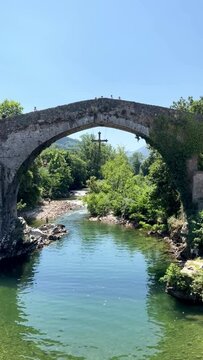 vertical video of Old Roman stone bridge in Cangas de Onis. Cangas de Onis roman bridge on Sella river in Asturias of Spain