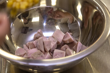 Sliced Pieces of chicken meat in a skillet, pulled chicken. Black background. Top view.