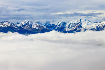 Beautiful view of snow-capped mountains above thick clouds in Bernese Oberland, Switzerland