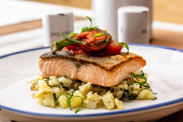 Salmon fillet grilled, fried potato and fresh vegetable green salad