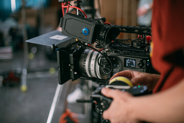 Fototapeta na wymiar Professional cinema and video camera on the set. Shooting shift, lighting fixtures, shooting equipment and the team.