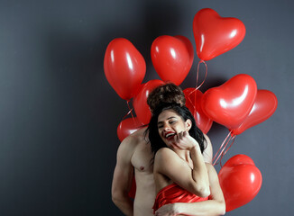 Kissing couple posing on white background with balloons heart. Valentine's day.
