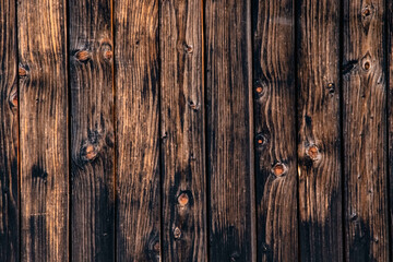 Wall of dark wooden planks in the background of a rural house. wood texture