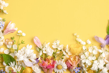 floral composition from different wildflowers on a light yellow background. Template for advertising and presentation of cosmetic products. Top view and copy space