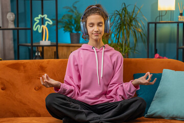 Keep calm down, relax. Preteen school girl breathes deeply with mudra gesture, eyes closed...