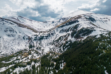 A snowy Hoverla and Breskul mountain range with a waterfalls, view from above
