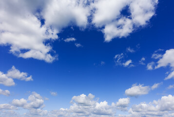 Photo of a clear blue sky and white clouds over horizon..