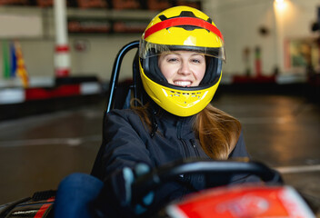 Glad cheerful positive woman driving sport car for karting in a circuit lap in sport club