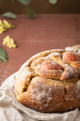 Portuguese traditional Easter cake with eggs. Typical Folar de Vale de Ilhavo, Aveiro, Portugal. Blossom flowers and colorful painted eggs decorated with feathers on easter table