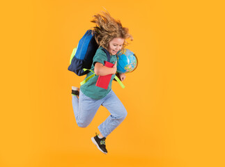 Fototapeta na wymiar Kid jump and enjoy school. School boy in school uniform with backpack jumping on yellow isolated background. Kids learning knowledge and kids education concept.