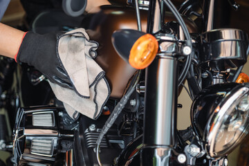 Biker clean a motorcycle , Polished and coating wax on fuel tank at garage. repair and maintenance...