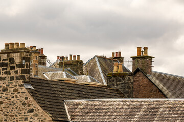 slate roofs and chimmneys with pots in a mostly victorian era scottish village room for text