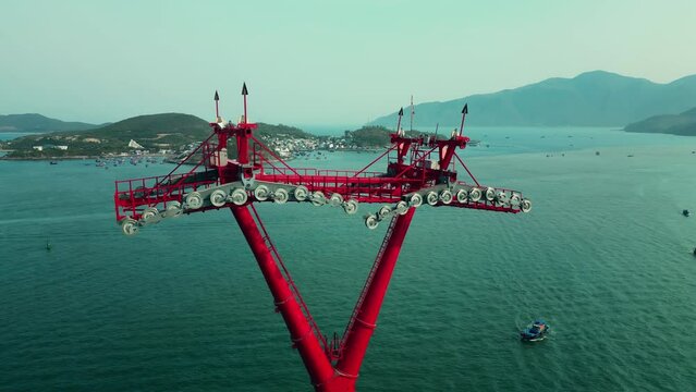 Top view above around huge structure of the power tower of the cable car in the sea with a length of several kilometers, one longest cable cars in the world. Support movement funicular cable car. 4K.