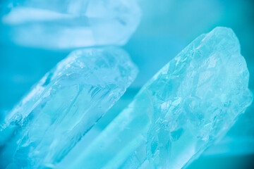 Rock crystal macro texture in blue light.transparent quartz crystals background in blue tones.texture of gemstone. crystals of natural transparent stone rock.Texture of natural stone Rock crystal