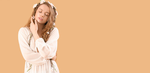 Beautiful young woman with flowers in her hair on beige background with space for text. Summer...