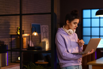 Young female programmer with laptop in office