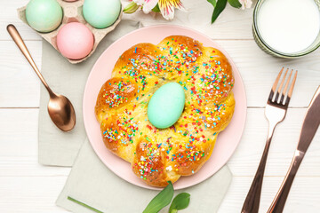 Composition with tasty Italian Easter bread, eggs and glass of milk on light wooden background