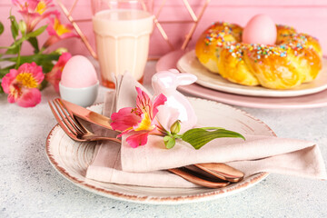 Obraz na płótnie Canvas Beautiful table setting with tasty Italian Easter bread, glass of milk and alstroemeria flowers on light table