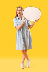 Happy young woman with blank speech bubble on yellow background