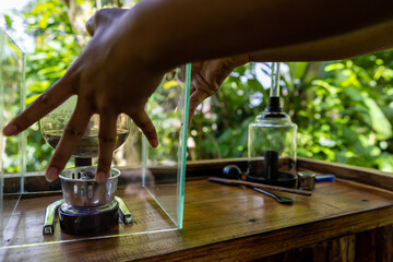 Bali, Indonesia  A woman prepares Luwak coffee at a coffee plantation for degustation through percolation.