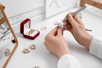 Female jeweler making ring on white table, closeup - Powered by Adobe