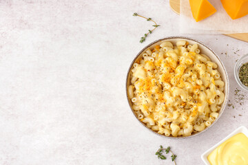 Bowl of tasty Italian pasta with Cheddar cheese on light background