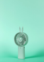 Green Portable Handheld Mini Cooling Fan isolated on Green background, Shadow © Leftsea