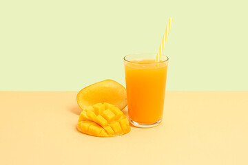 Glass of fresh mango smoothie on color background