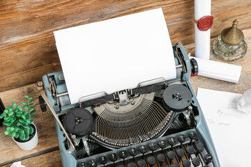 Vintage typewriter, inkwell, houseplant and scrolls with wax seal stamps on brown wooden background