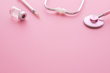 Obraz na płótnie Canvas ピンクの背景に聴診器や注射の医療器具　女性の病気や病院のヘルスケアイメージ写真　レディースクリニック