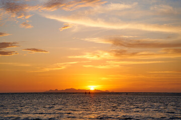 Incredible colors of the sunset sky with marshmallow clouds over the ocean