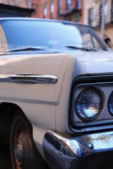 Fototapeta premium Front end of an old white automobile from the 1960s