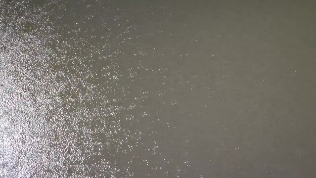 Raindrops on the surface of the water at night 