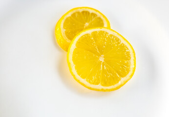 Fototapeta na wymiar Lemon slices on the white plate, Lemon slices on the white background, 2 pieces lemon prices on the white background.