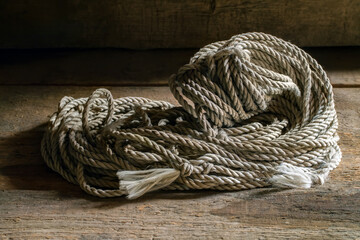 Old rope. A coil of rope on a background of old wood.