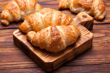Two  delicious croissants on a wooden cutting board