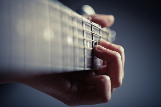 Color Detail Of Hands Playing Of An Old Acoustic Guitar