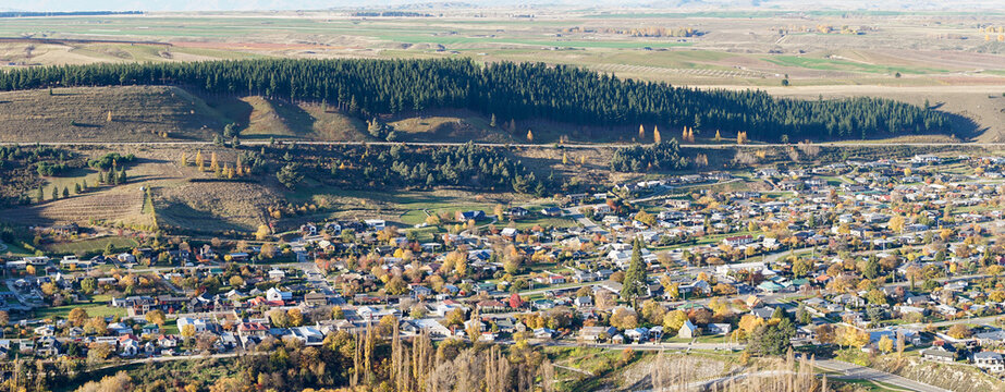 Clyde town an aerial view: Picturesque, lush greenery, houses, trees, nestled by a mountain.